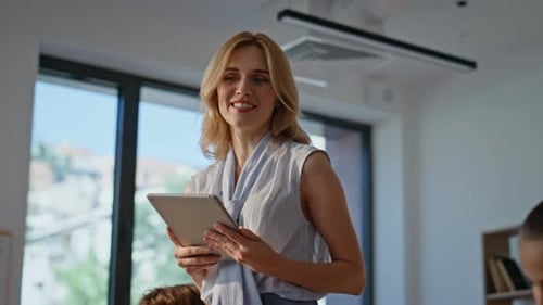 Woman Teaching Students with Tablet in Classroom