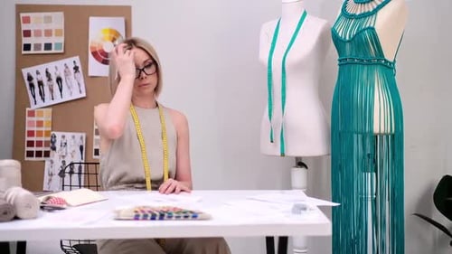 Woman with Glasses Works Upon Elegant Apparel Sketch in Fashion Studio Clothes Designer in Studio