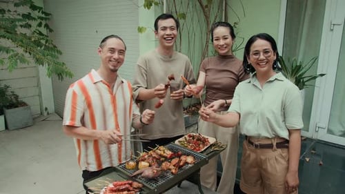 Smiling Friends Enjoying Barbecue Together at Home