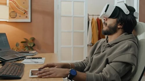 Software Developer Using VR Goggles while Working from Home