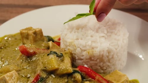Green Curry Tofu Soup Cooking Thai Green Curry Soup in a White Bowl on a White Plate with Dark