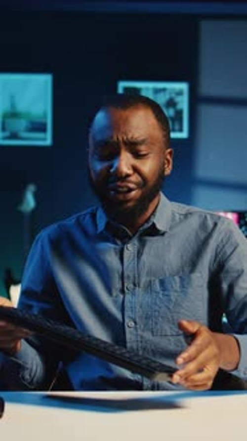 Man Showing Computer Keyboard and Mouse to Camera