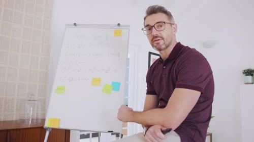 Man Explaining Math Problem at Whiteboard in Home