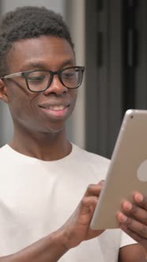 Young Man Uses Tablet Indoors Close Up