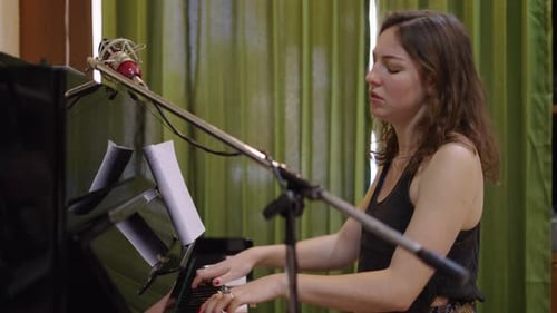 Woman Plays Piano and Sings in Recording Studio