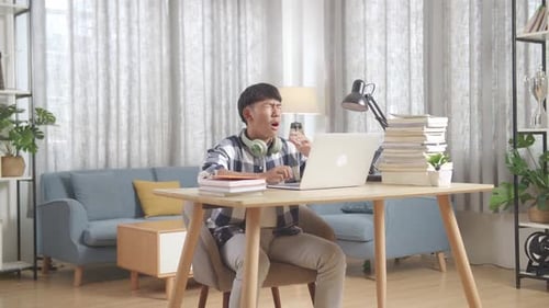 Bored Asian Teenager Yawning While Doing Home Work On Laptop, Student Learning Online At Home
