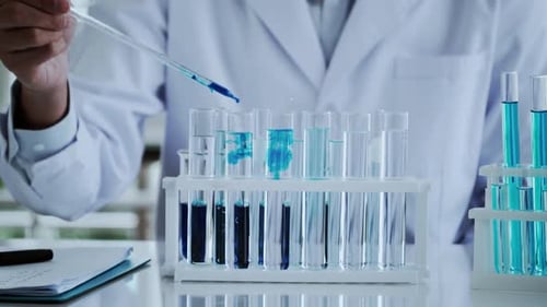 Blue Liquid Being Added to Test Tubes in Lab