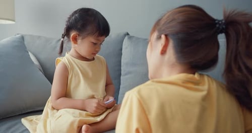 Girl and Mother on Gray Sofa