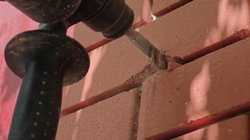Jackhammer Breaking Red Brick Wall