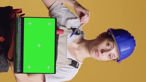 Vertical Video Portrait of Handywoman Holding Laptop with Greenscreen Display