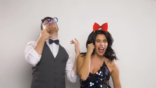 Couple celebrate wearing party photo booth props indoors