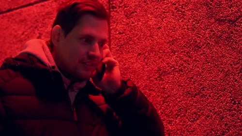 Man Talking on Cell Phone Under Red Light