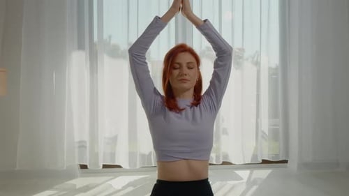 Woman Practicing Yoga Indoors in Natural Light