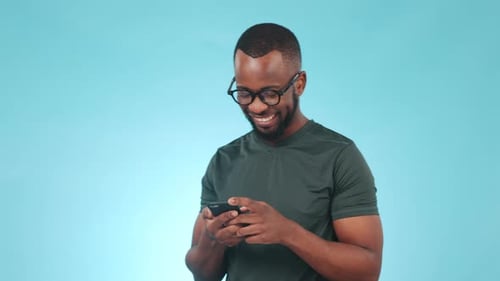 Smile, phone and black man in a studio typing a message on social media, mobile app or the internet