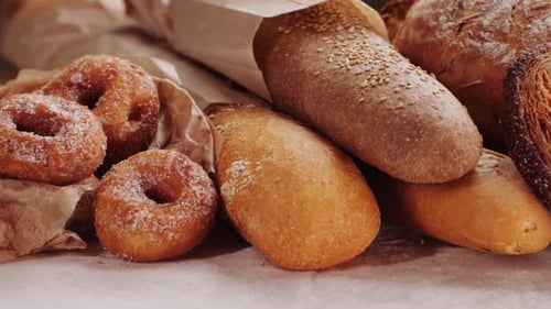 Pain présenté par le boulanger : assortiment de baguettes espagnoles et de desserts traditionnels de boulangerie