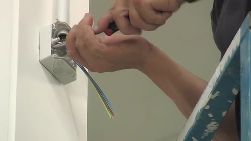 Electrician Connecting Wires to Electrical Box with Screwdriver