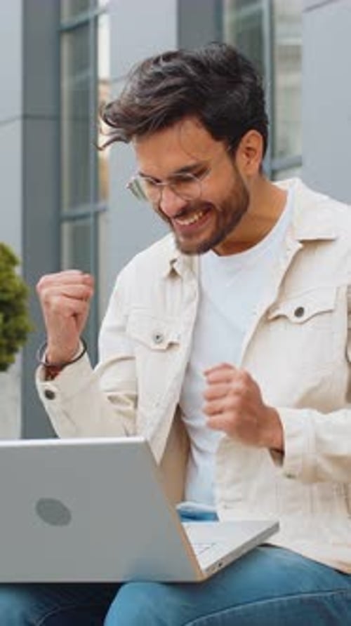 Happy Indian Man Working on Laptop Celebrate Success Win Money Get Online Good News Outdoors Street