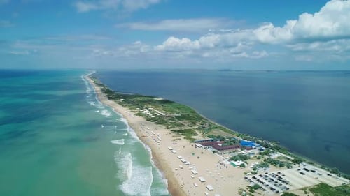 Aerial Over the Long Sandy Spit with a Beach and Azure Water on a Sunny Summer Day Waves Crashing to