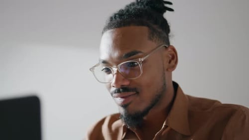 African american freelancer working laptop at home office closeup with eyeglasses
