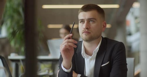 Un directeur qualifié dans un bureau d'affaires utilise un stylo pour envisager de nouvelles entreprises commerciales