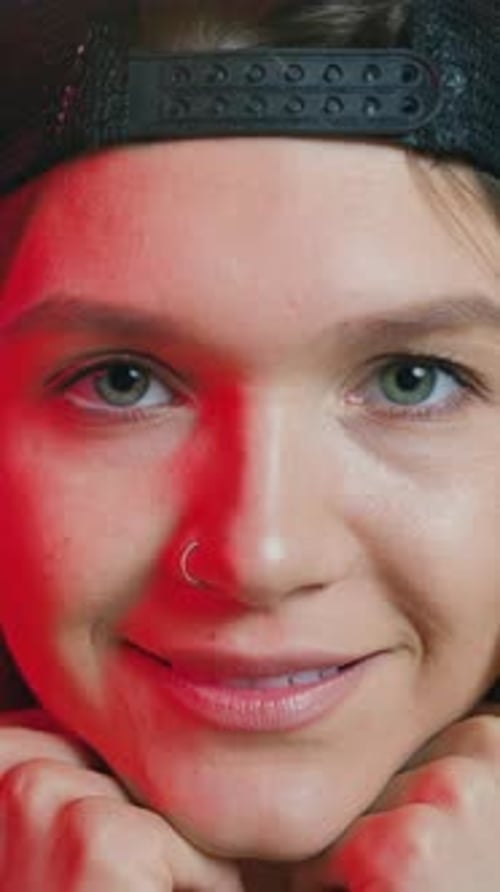 Charmante fille de 25 ans, confiante, positive et élégante, avec boucle d'oreille dans le nez et tenant sa tête