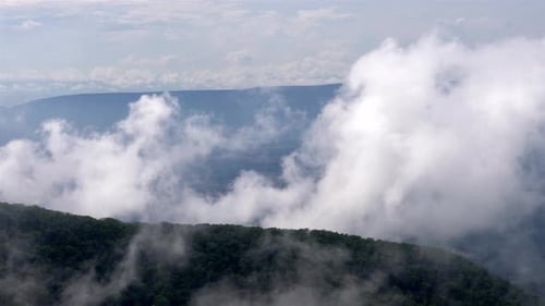 Handheld footage captures mesmerizing mountain vista as clouds slowly drift from lower left to upper