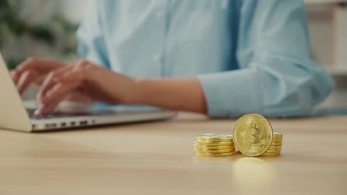 Close Up of Gold BTC Coins That Successful Young Woman Hold at Home