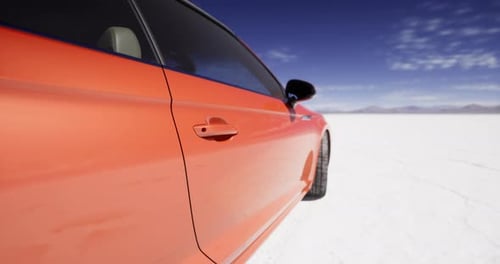 Modern Orange Sports Car Panning on a Vast White Landscape