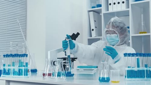 Scientist Working in Laboratory with Pipette and Test Tubes