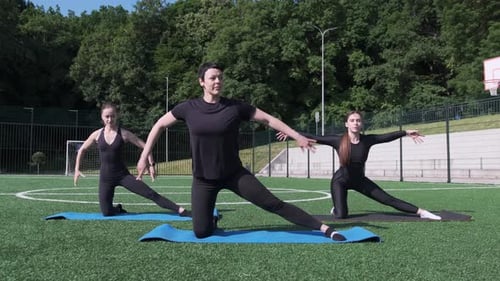 Women Stretching on Mats in Outdoor Park Setting