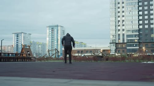 Man Juggling Football on Urban Sport Arena with Scenic Cityscape Background