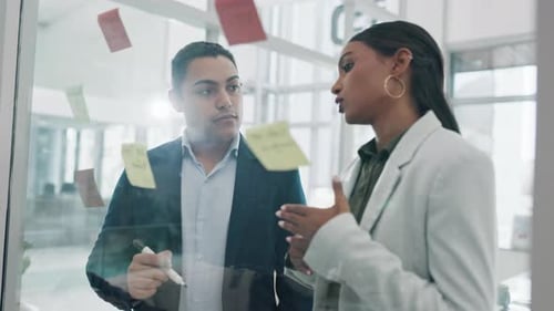 Teamwork, glass wall and business people planning, brainstorming and schedule in office