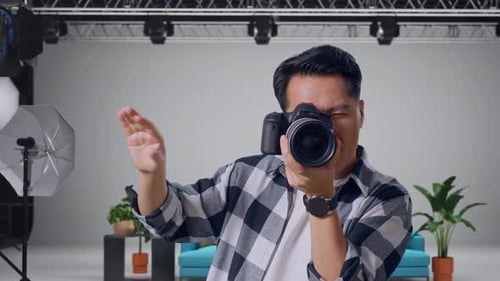 Asian Photographer Telling The Model To Move Left And Right While Taking Pictures In The Studio