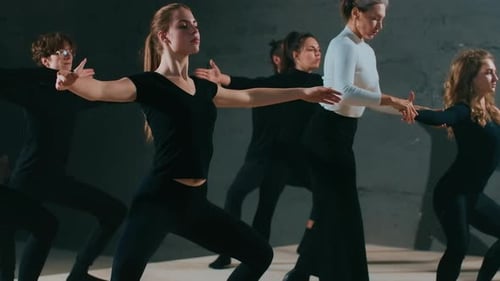Dance Students Practicing Movement in Gray Studio