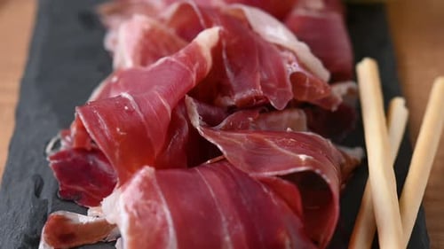 Scheiben spanischen Serrano-Schinkens auf Holztisch