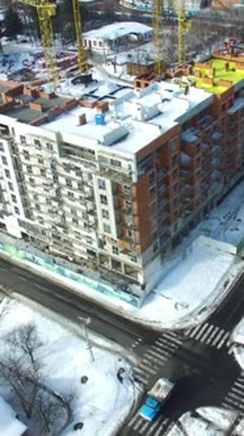 Edificio de
nueva construcción. Sitio de construcción de grúas y edificios en invierno