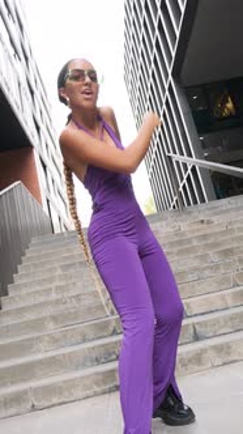 Young Woman in Jumpsuit Dancing in City
