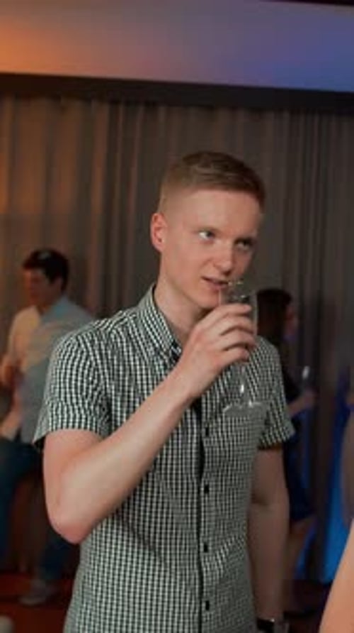 Young Man Drinks Wine, Shares Glass with Woman