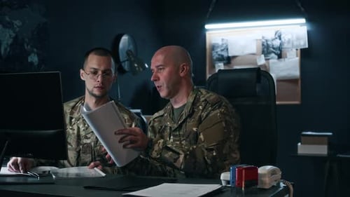Two Officers Analyzing Data and Communicating at Command Center