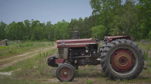 Tractor sitting outside in a field on a sunny day on a farm