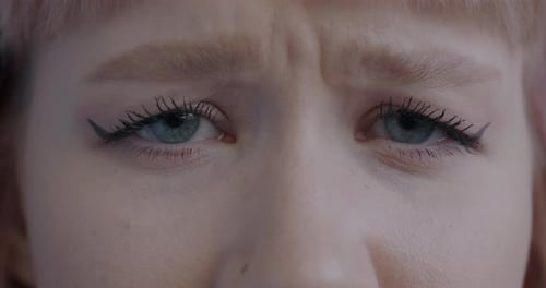 Closeup Portrait of Unhappy Young Woman's Eyes Looking at Camera Blinking