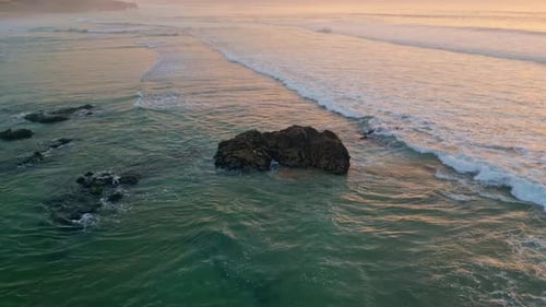 Calm Ocean Evening Scenery with Foamy Surf Rolling to Empty Coastline Drone View