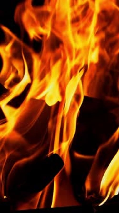 Lagerfeuer. Das Feuer wird in der Nacht angezündet. Vertikales Video in Zeitlupe