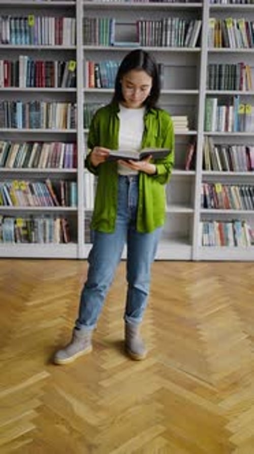 Young Book Lover Reads Book in Library with Joyful Smile