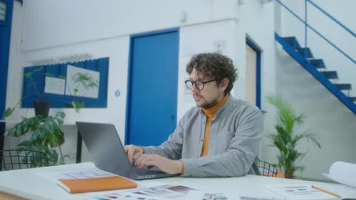 Architect Typing on Laptop while Working in Office