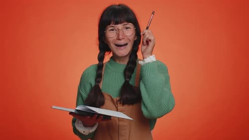 Young Woman Thinking and Writing in Notebook