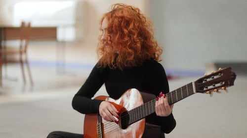 Woman with Red Hair Plays Guitar