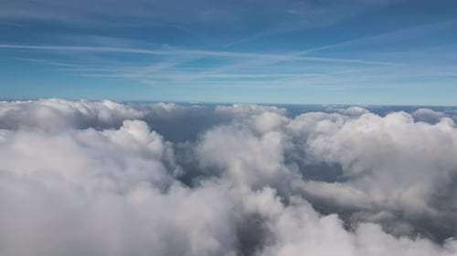 Aerial View From Airplane Window at High Altitude of Earth Covered with Puffy Cumulus Clouds Forming