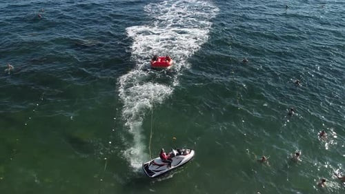 Jet Ski Pulls Raft With People in Sea