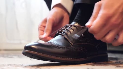 Man Tying Shoe Laces on Brown Dress Shoe